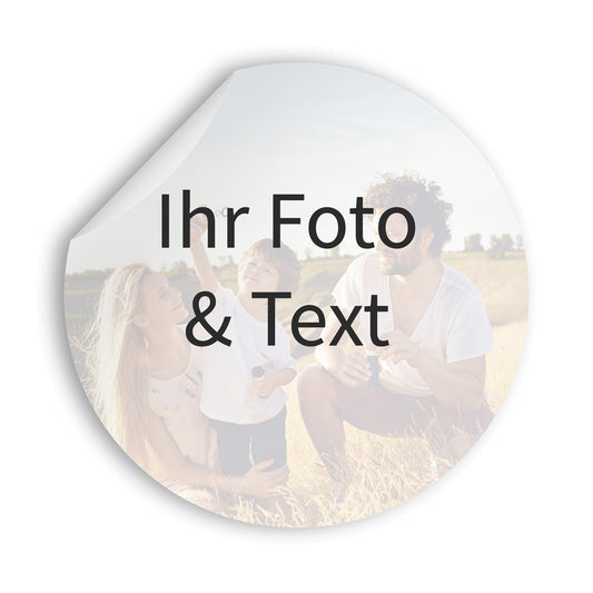 Vorschau eines personalisierbaren runden Aufklebers mit eigenem Foto und Text. Das Beispielmotiv zeigt eine Familie auf einer Wiese. Die obere Ecke des Stickers ist leicht abgelöst, um die Materialstruktur darzustellen. Perfekt für individuelle Gestaltung, Werbezwecke oder Dekoration.