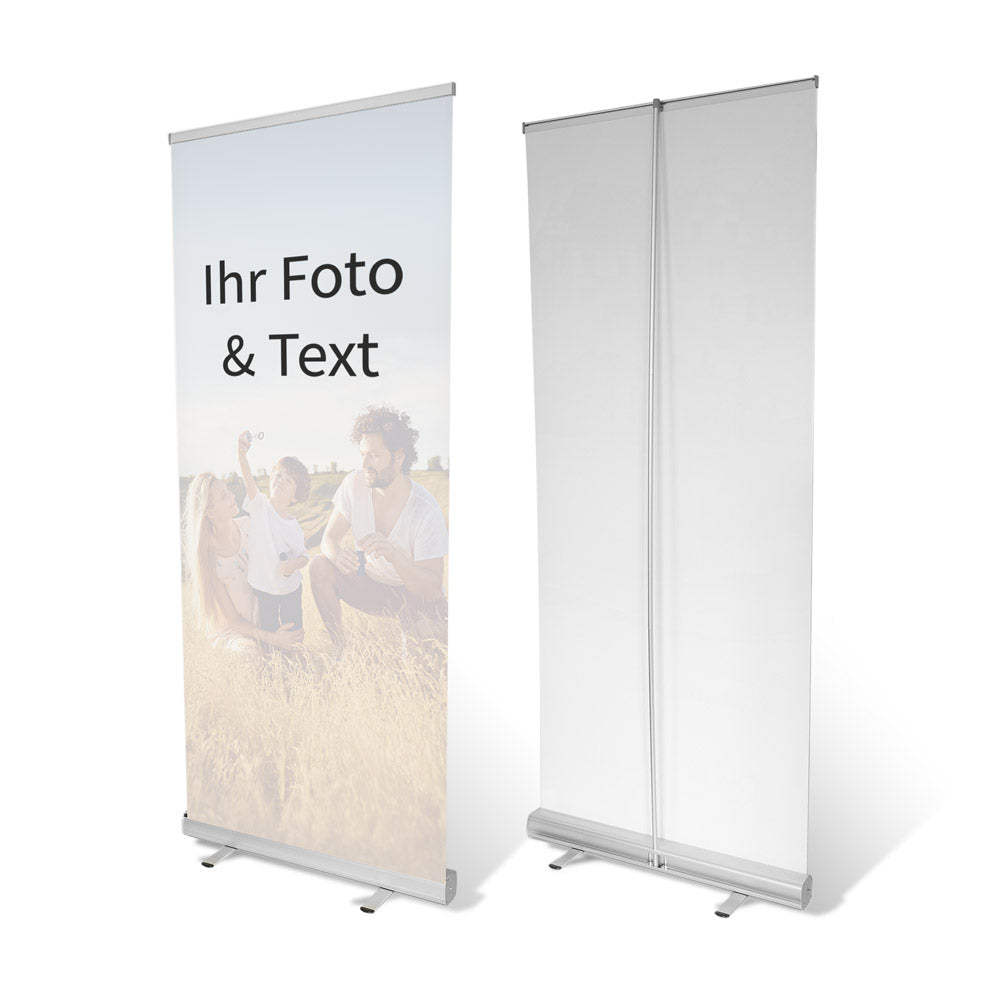 Beidseitige Ansicht eines personalisierbaren Rollup-Banners mit eigenem Foto und Text. Das Beispielmotiv zeigt eine Familie auf einer Wiese, während die Rückseite des Banners in neutralem Weiß dargestellt wird. Ideal für Werbezwecke, Messen, Veranstaltungen oder individuelle Dekoration.