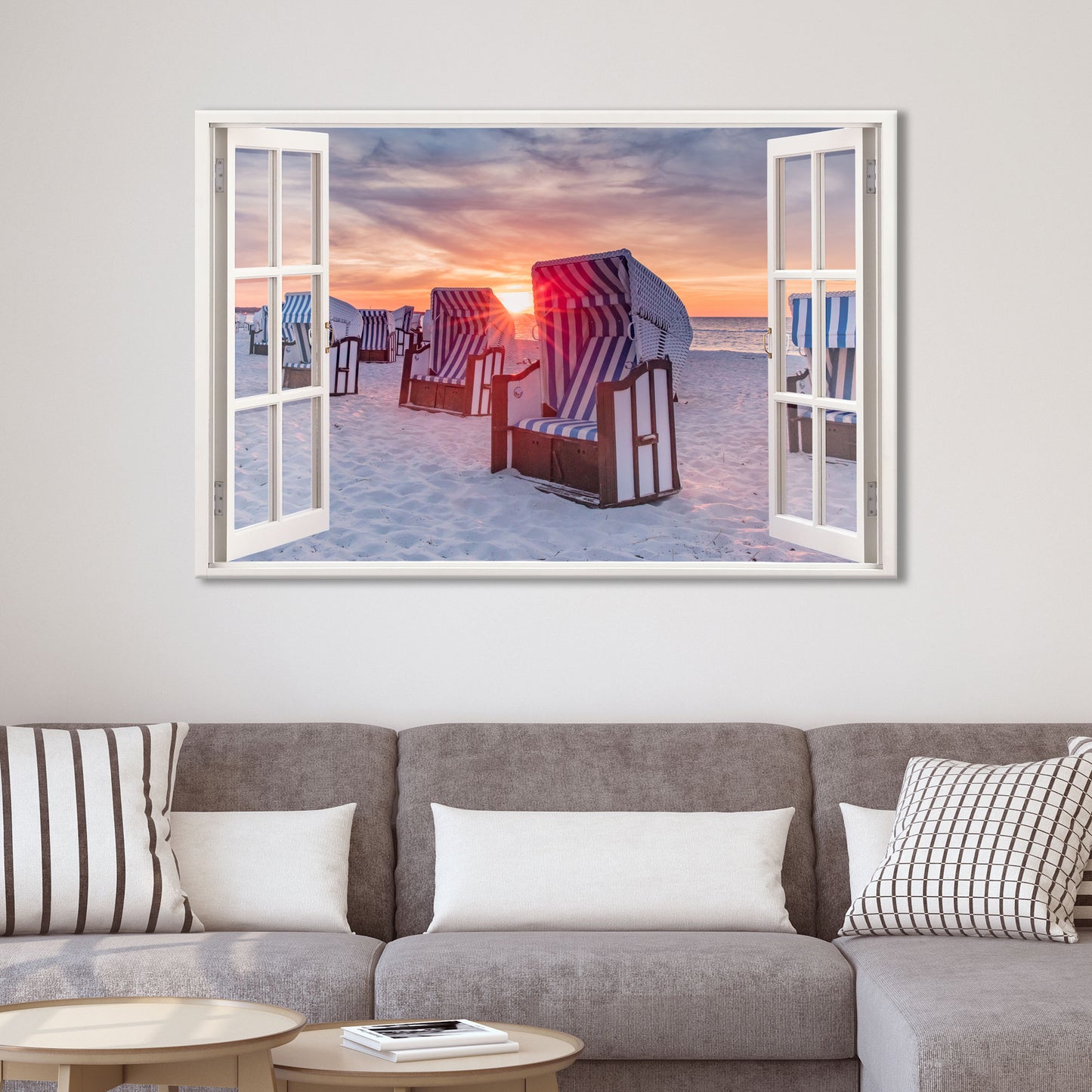 Fototapete mit offenem Fensterblick auf einen Sandstrand mit blau-weiß gestreiften Strandkörben beim Sonnenuntergang. Die warme Abendsonne taucht die Szene in ein stimmungsvolles Licht. Perfekt als Wanddekoration für Wohnzimmer oder Schlafzimmer.