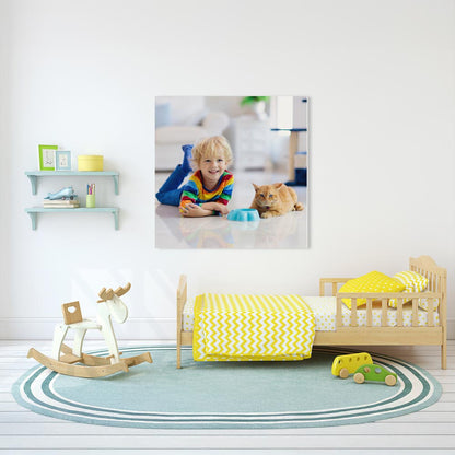 Modern eingerichtetes Kinderzimmer mit einem Bett, einem Schaukelpferd und Regalen. An der Wand hängt eine personalisierte Fotoleinwand mit einem fröhlichen Kind in buntem Pullover, das neben einer Katze liegt. Die Wanddekoration verleiht dem Raum eine individuelle und gemütliche Atmosphäre.