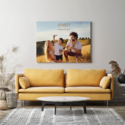 Moderne Wohnzimmerdekoration mit einer personalisierten Leinwand über einem senfgelben Sofa. Die Leinwand zeigt eine Familie auf einer Sommerwiese mit dem Schriftzug 'Lovely Memories'. Perfekt als individuelle Wandgestaltung und als besonderes Geschenk für Erinnerungen an schöne Momente.
