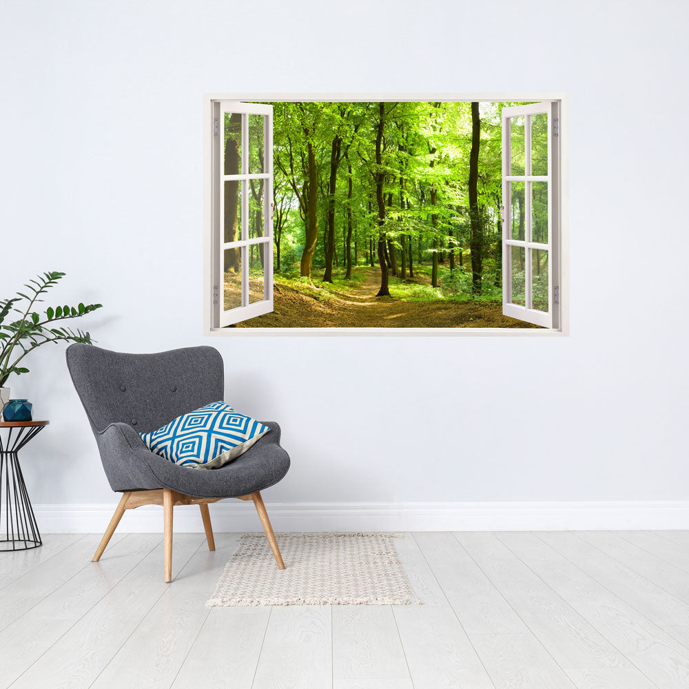 Offenes Fenster mit Blick auf einen grünen Waldweg im Frühling. Im Vordergrund steht ein moderner grauer Sessel mit einem Kissen in Blau und Weiß. Der Raum ist minimalistisch eingerichtet, mit einem kleinen Pflanztisch im Hintergrund.