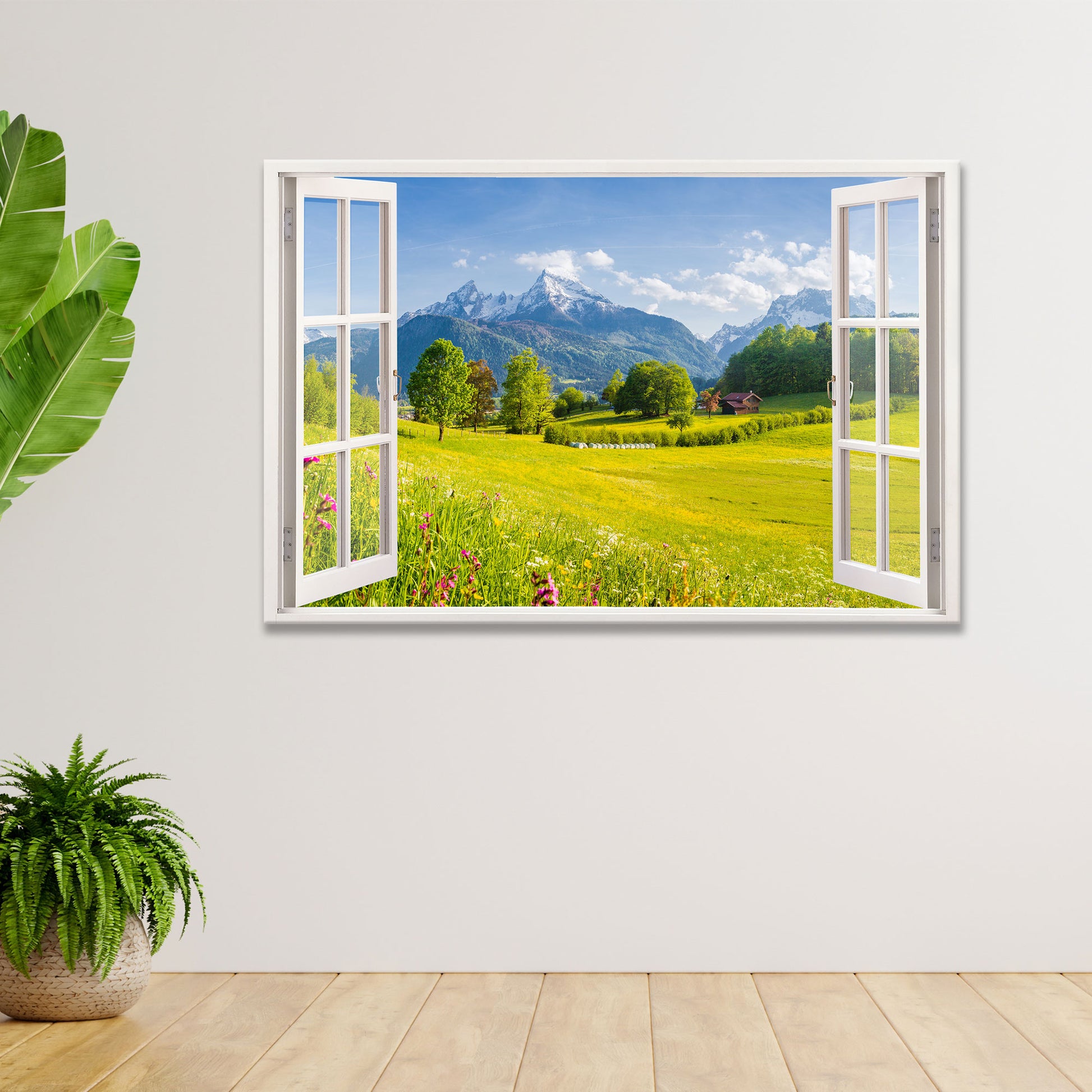 Stilvolles Wandbild mit offenem Fensterblick auf eine idyllische Berglandschaft mit grünen Wiesen, bunten Blumen und schneebedeckten Gipfeln. Das Leinwandbild schafft eine beruhigende Atmosphäre und ist perfekt für moderne Wohnräume. Links im Bild steht eine dekorative grüne Pflanze auf einem Holzboden.